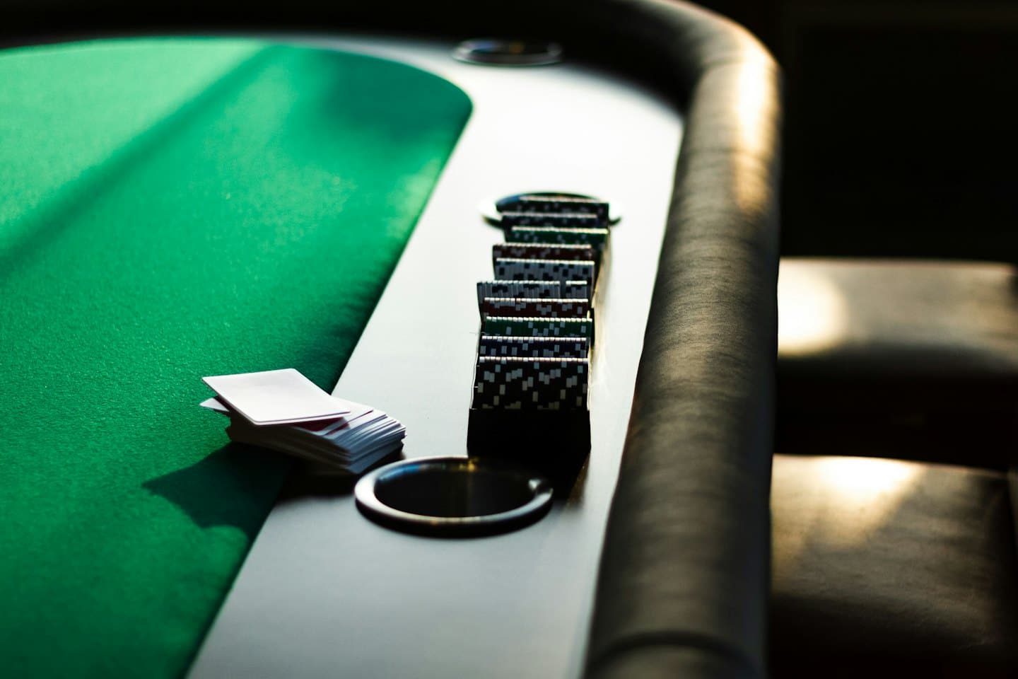 Playing cards and poker chips resting on a wooden table.